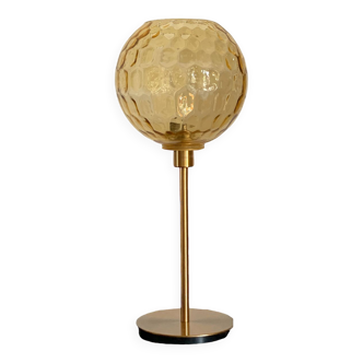 Table lamp with an old amber embossed globe and a golden foot