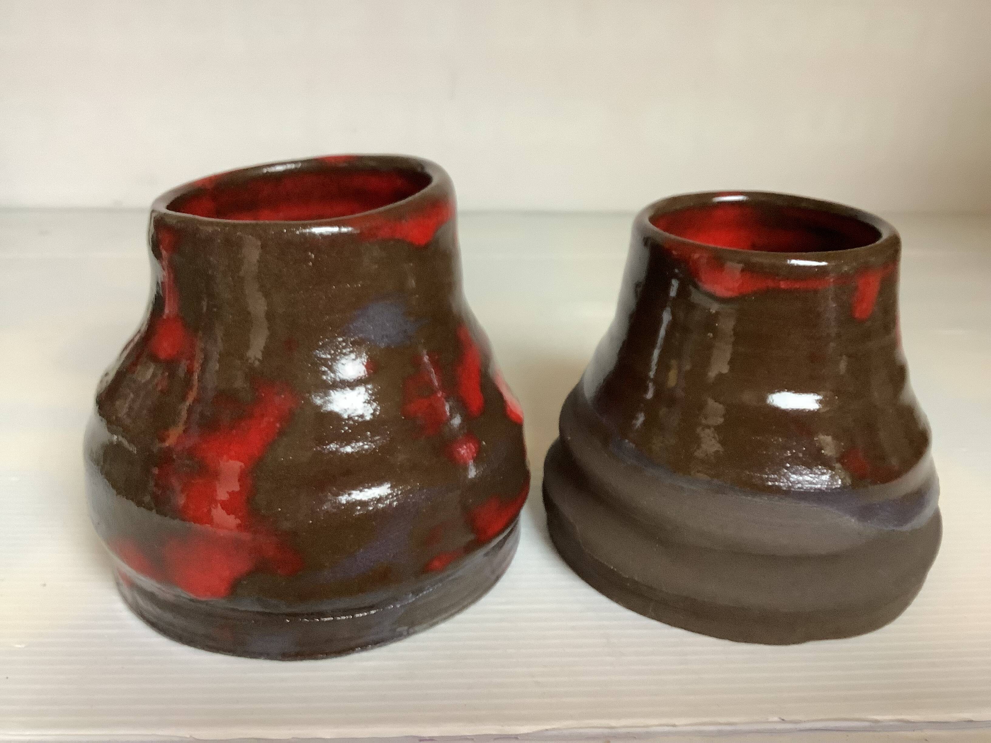 Pair of red vases in the shape of an elephant's foot