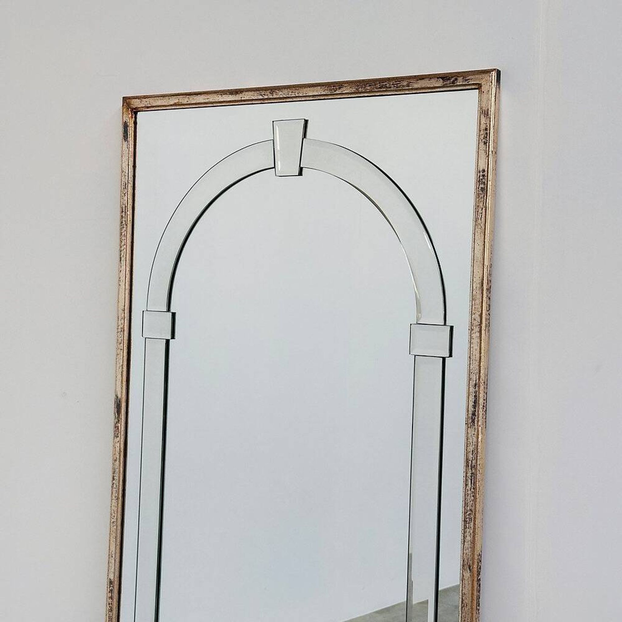 Grand miroir mural en verre biseauté de style Art Déco avec design d'arc architectural.