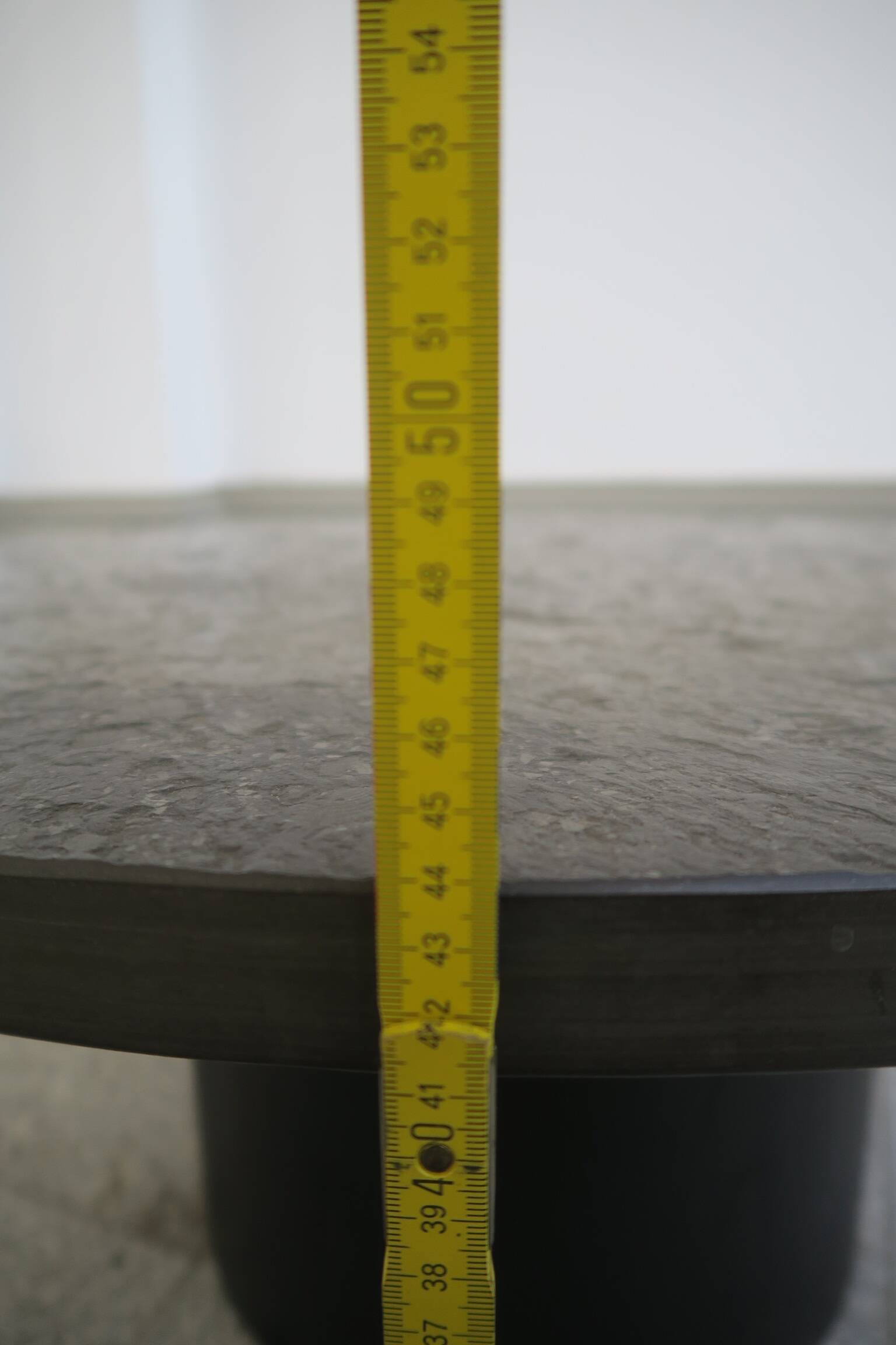 table basse ronde avec plateau en ardoise noire par draenert studios