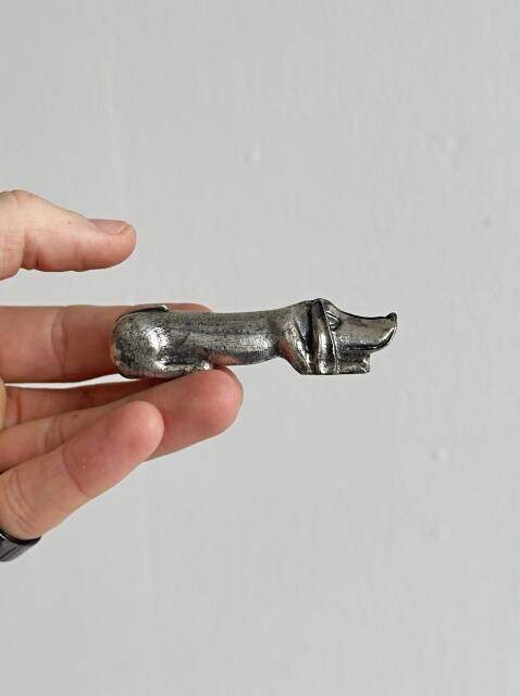Antique metal knife rest in the shape of a dog.
