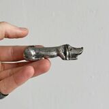 Antique metal knife rest in the shape of a dog.