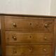 Rustic English pine chest of drawers with porcelain knobs.