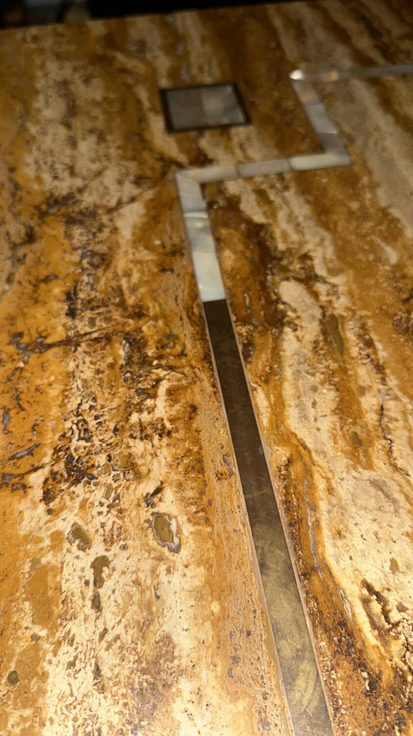 Coffee table in travertine with mother-of-pearl inlays.