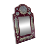 Large oriental mirror with embossed brass decoration on a red velvet background