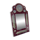 Large oriental mirror with embossed brass decoration on a red velvet background