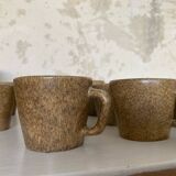 Set of stoneware coffee cups with saucers