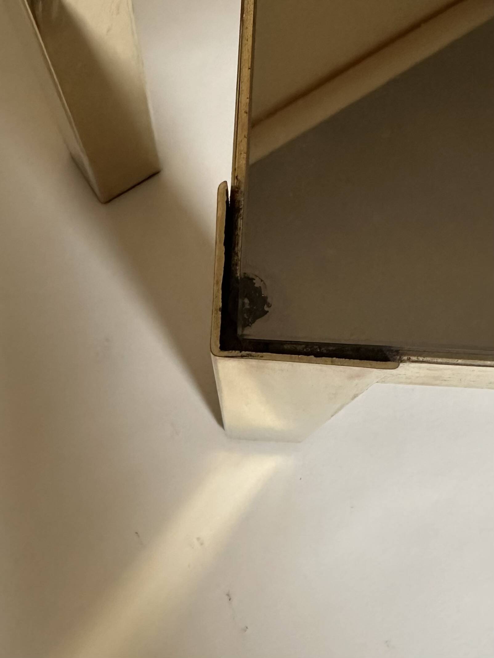 Set of three nesting side tables in brass and smoked mirror.