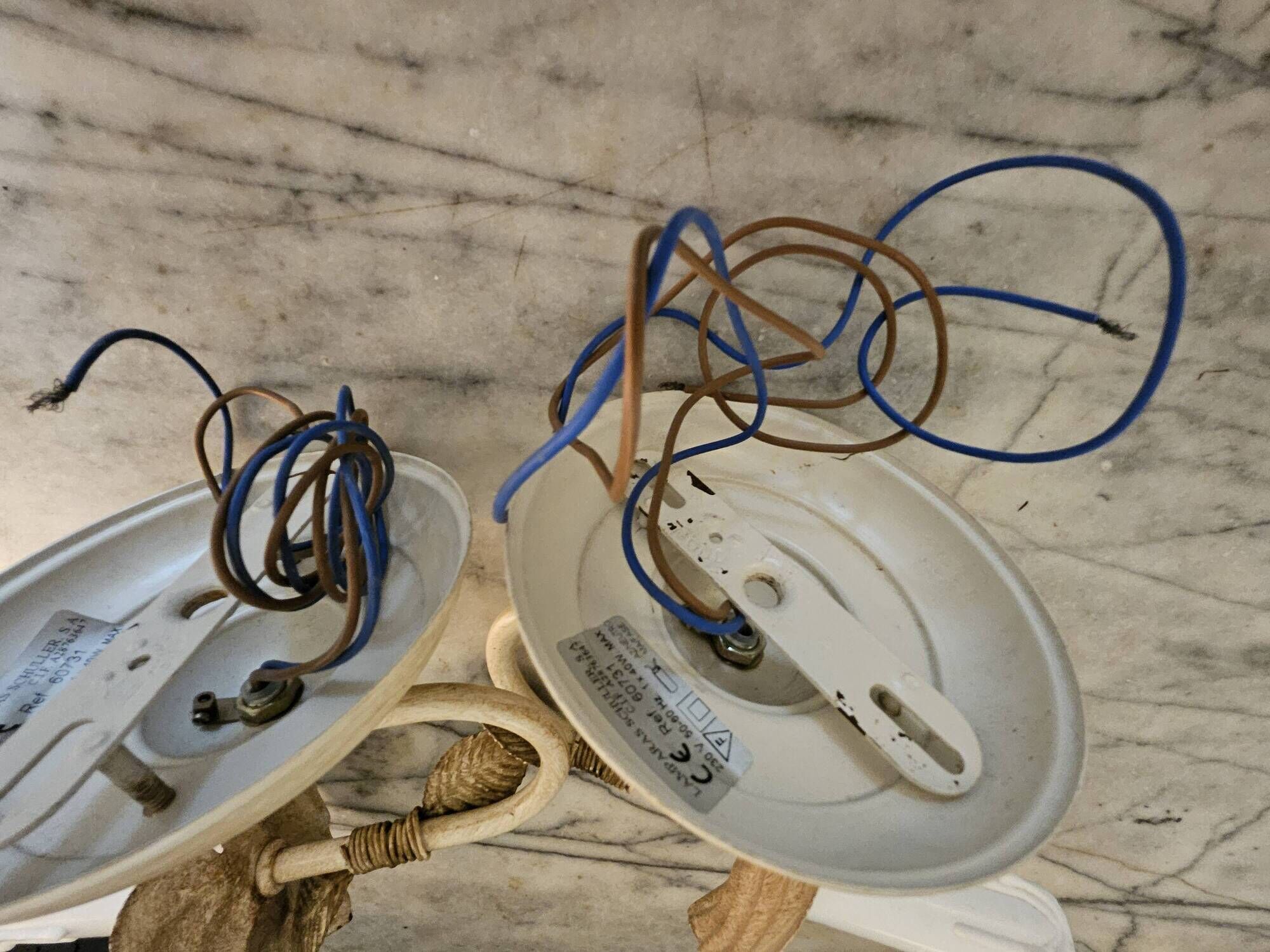 Pair of cream patinated metal wall sconces with floral decoration.