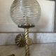 Pair of neoclassical wall sconces in twisted brass and ribbed glass.