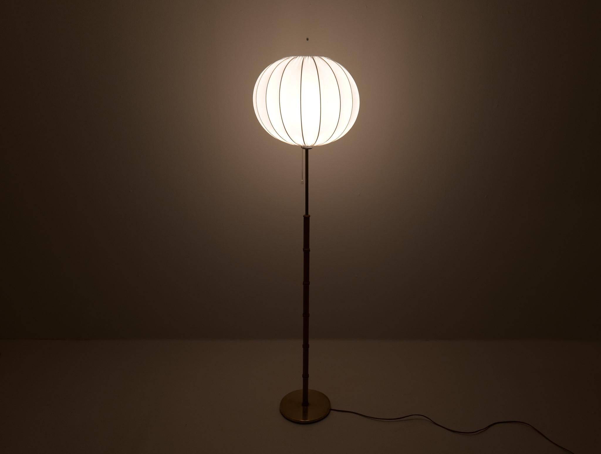 Mid-century floor lamp in brass and oak by Falkenbergs Belysning, Sweden, 1960s.
