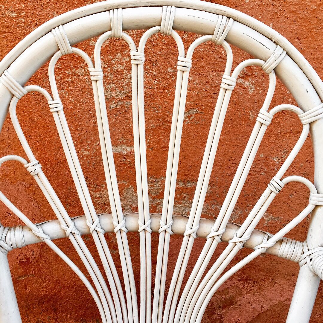 Two white rattan armchairs