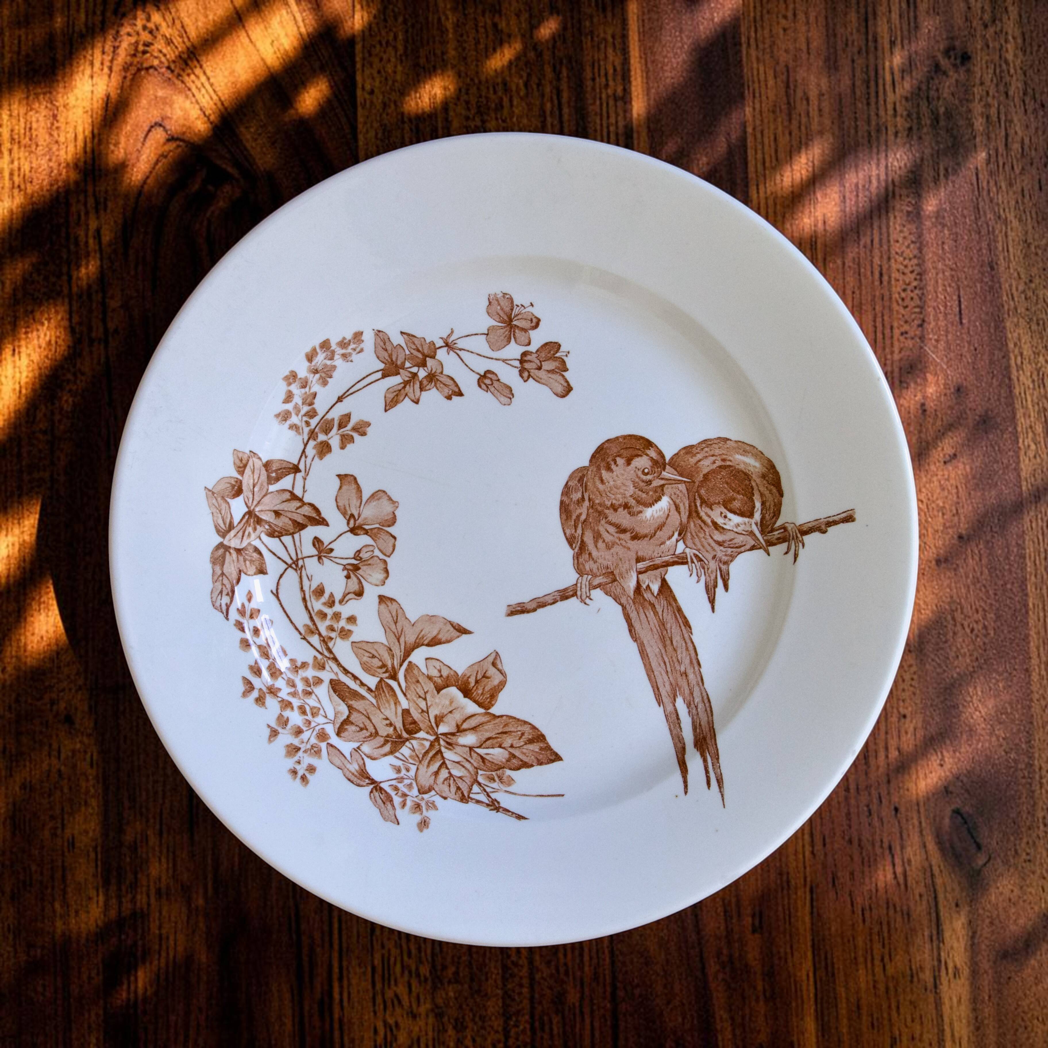 Large round dish from around 1870 signed Longwy with birds in sepia ironstone.