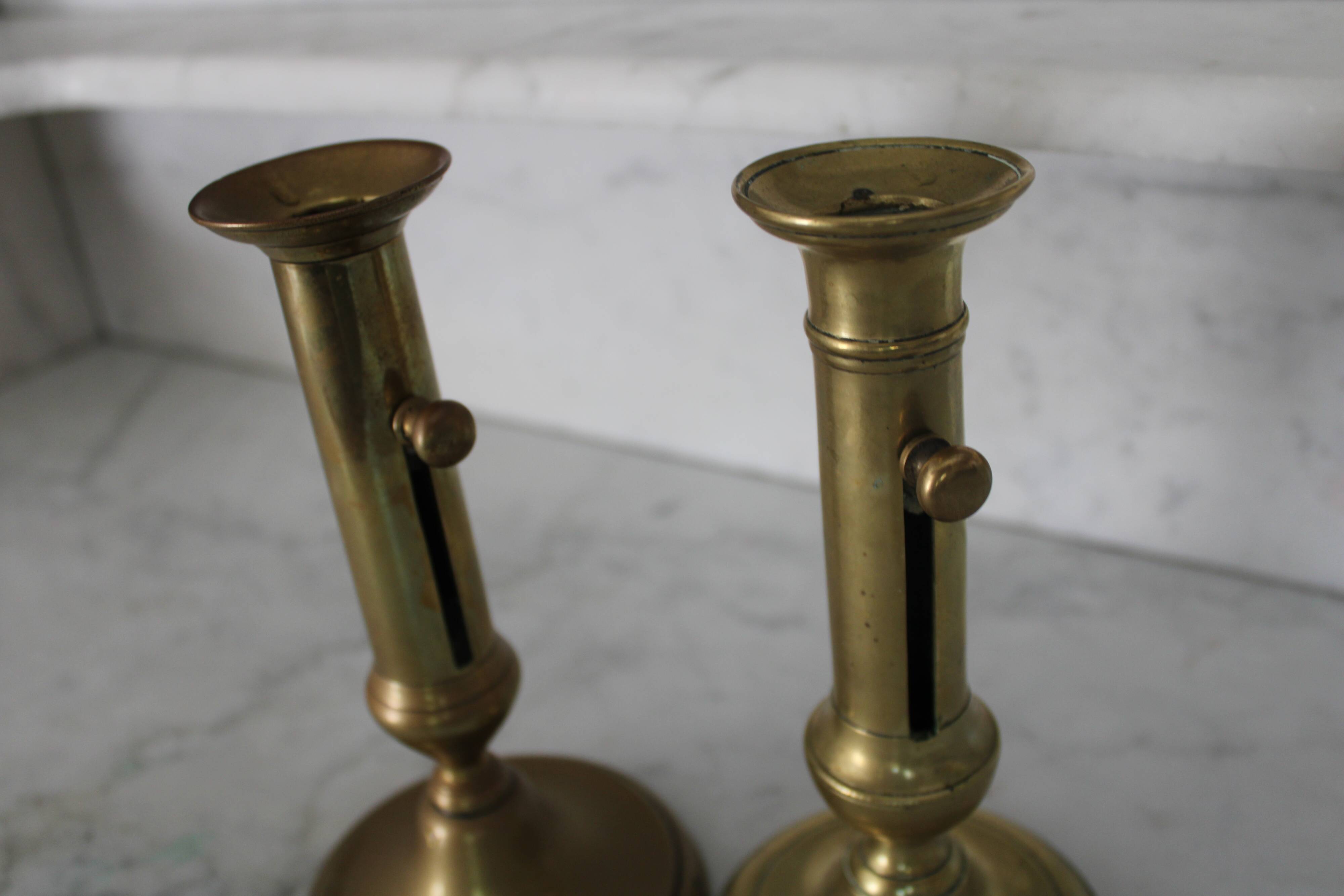 Pair of brass pusher candlesticks