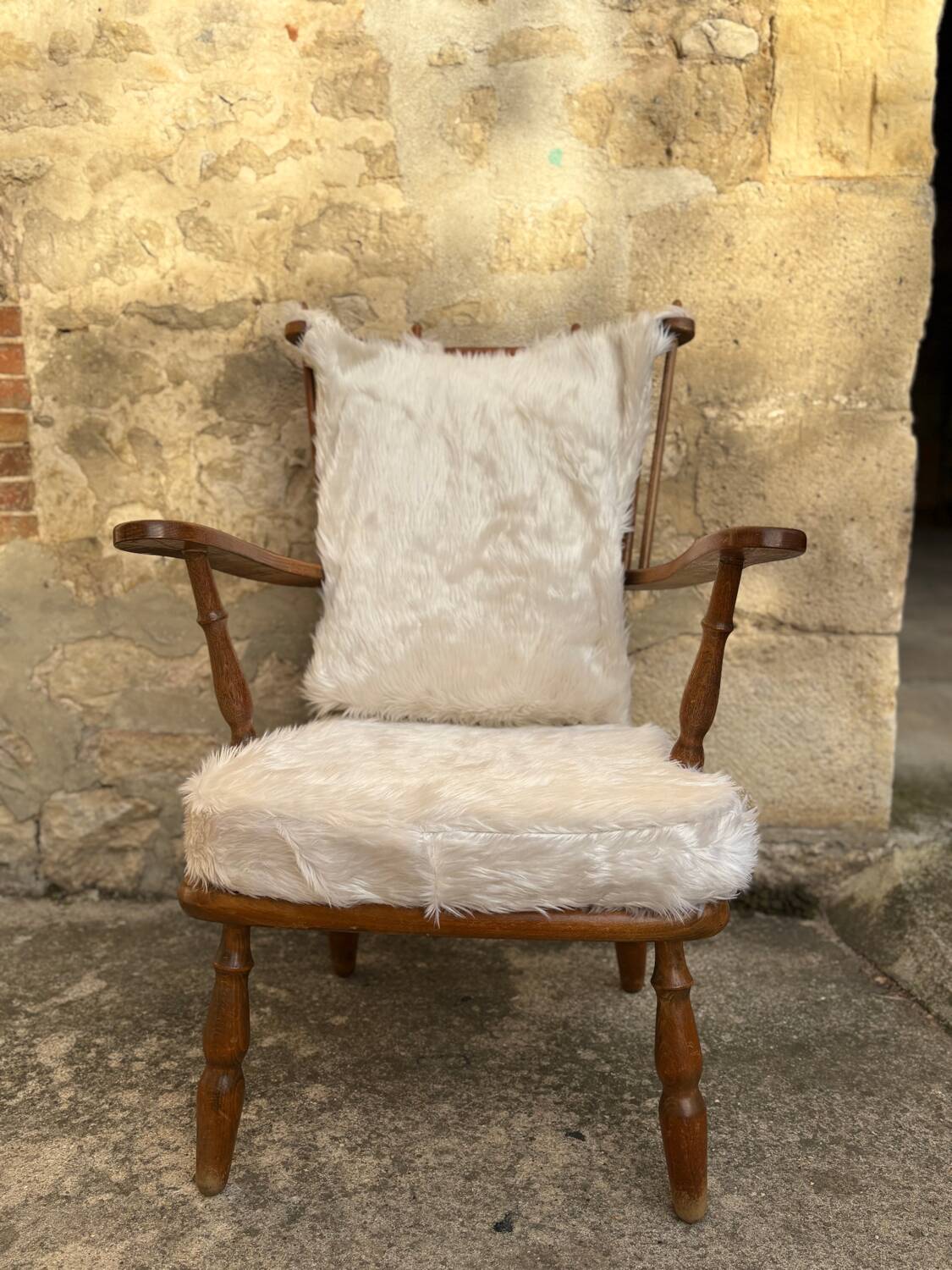 Scandinavian armchair in solid wood with beige fur cushion