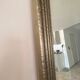Textured embossed metal wall mirror with bevelled mirror.