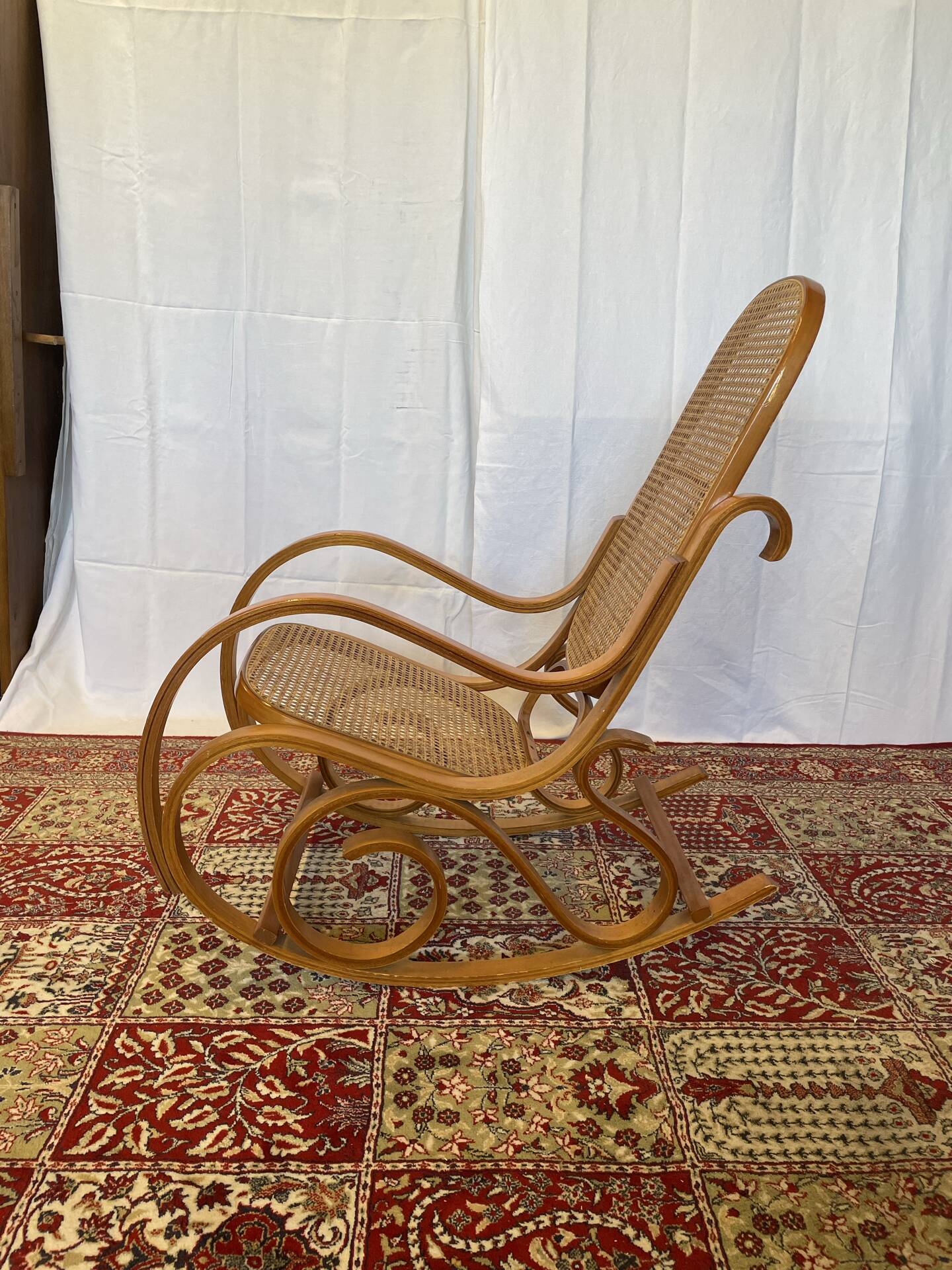 Antique rocking chair in curved wood and caning.
