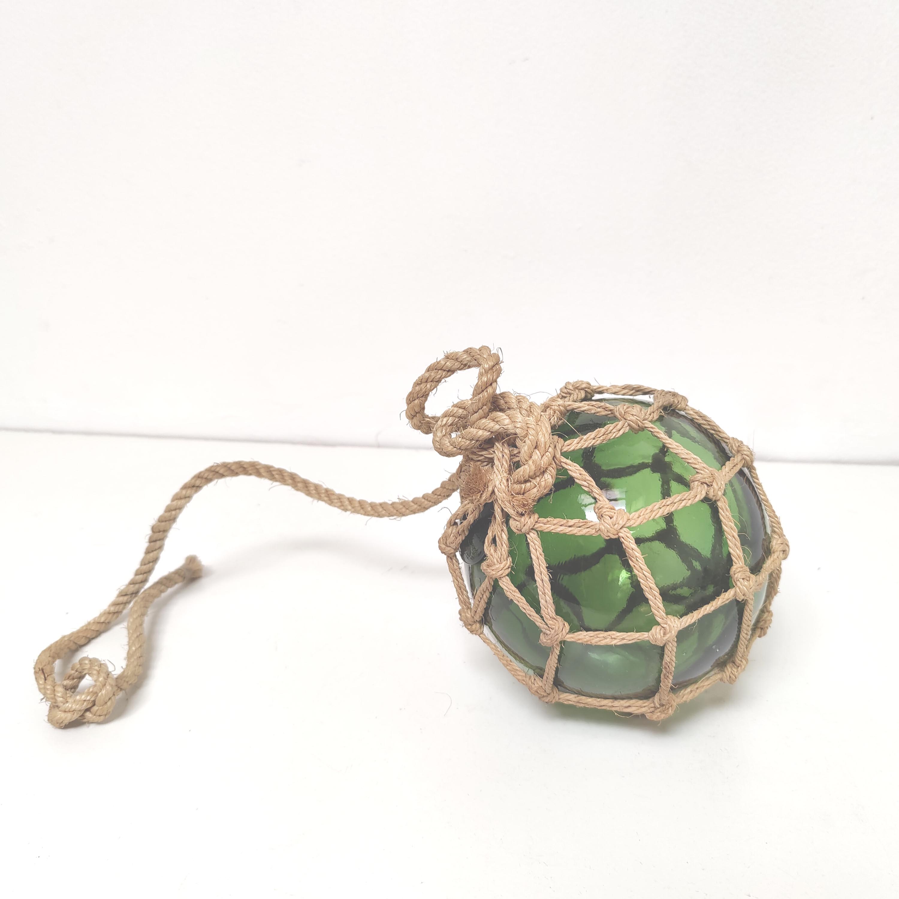 Green ball marine float in glass and rope