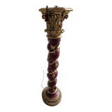 red and gold wooden column in the shape of a vine foot topped with a lamp