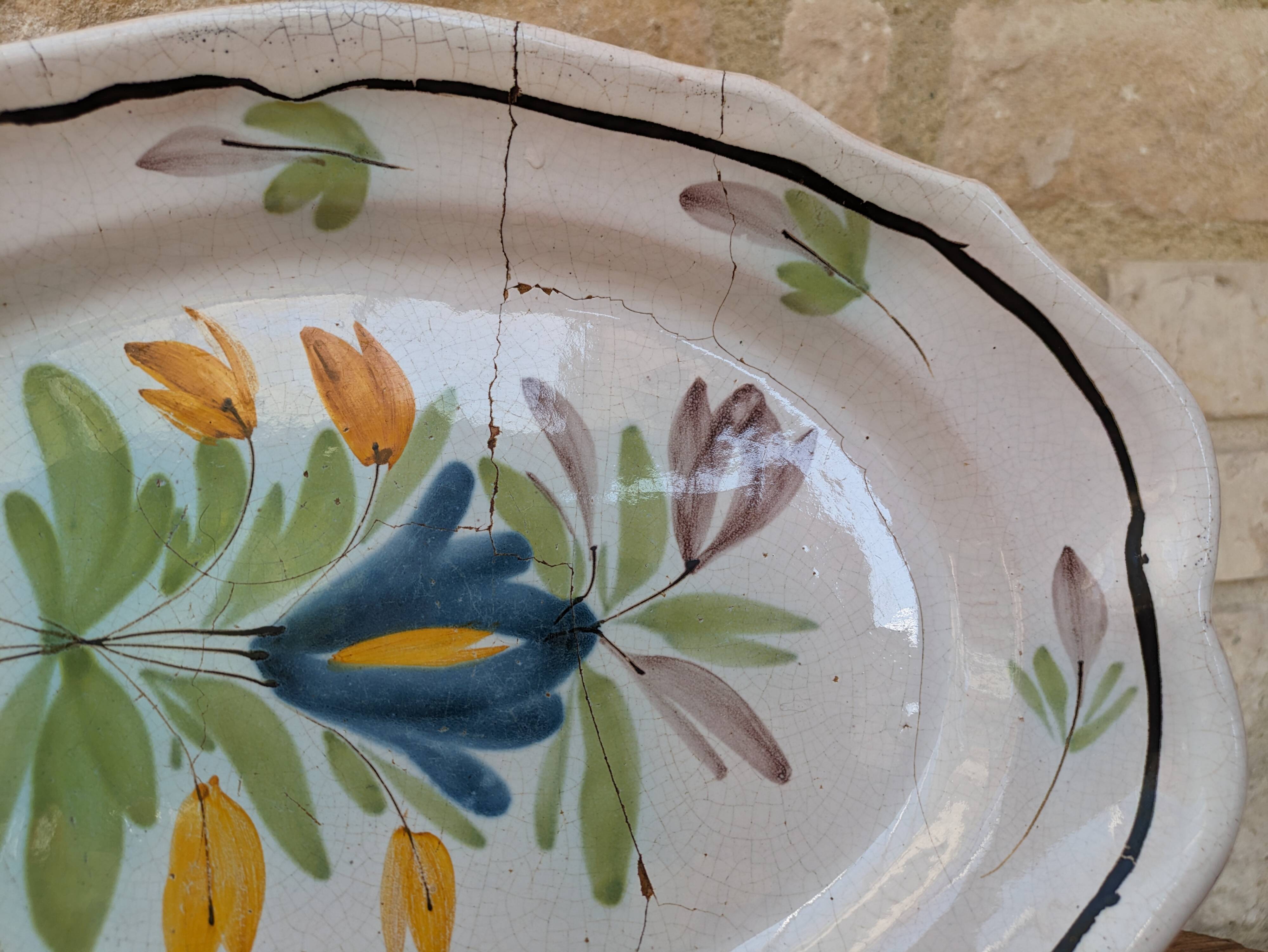 Old oval dish with floral motif called black bottom with staples