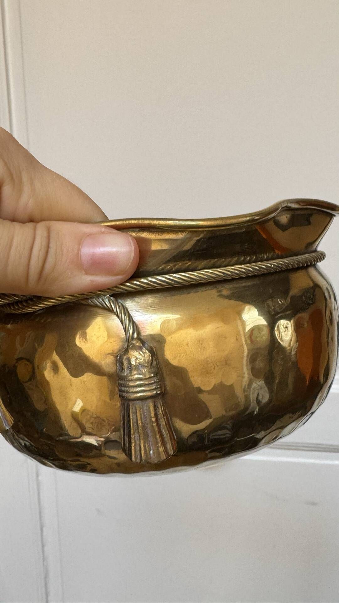 Pair of brass plant pots, decorated with cord and tassels.