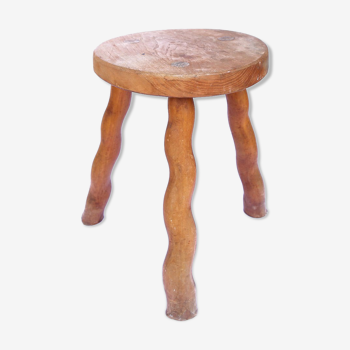 Tripod stool of folk art in light wood and wavy feet