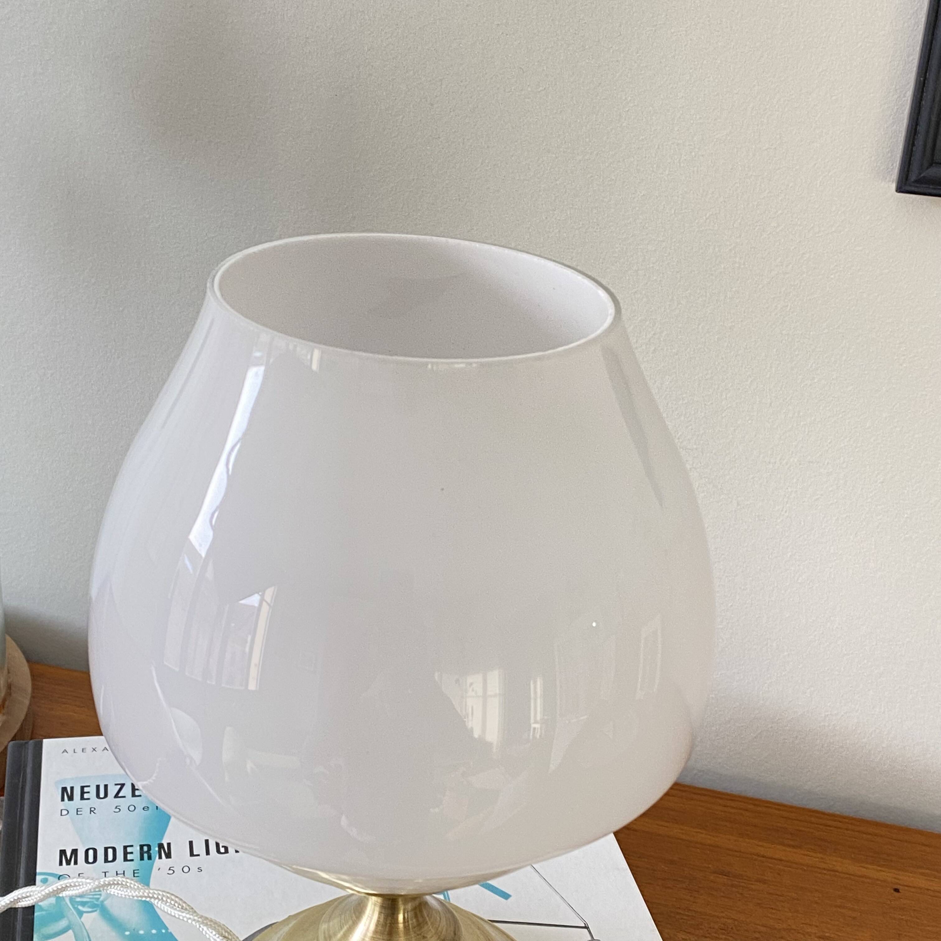 Antique white opaline glass globe table lamp with a brass base.