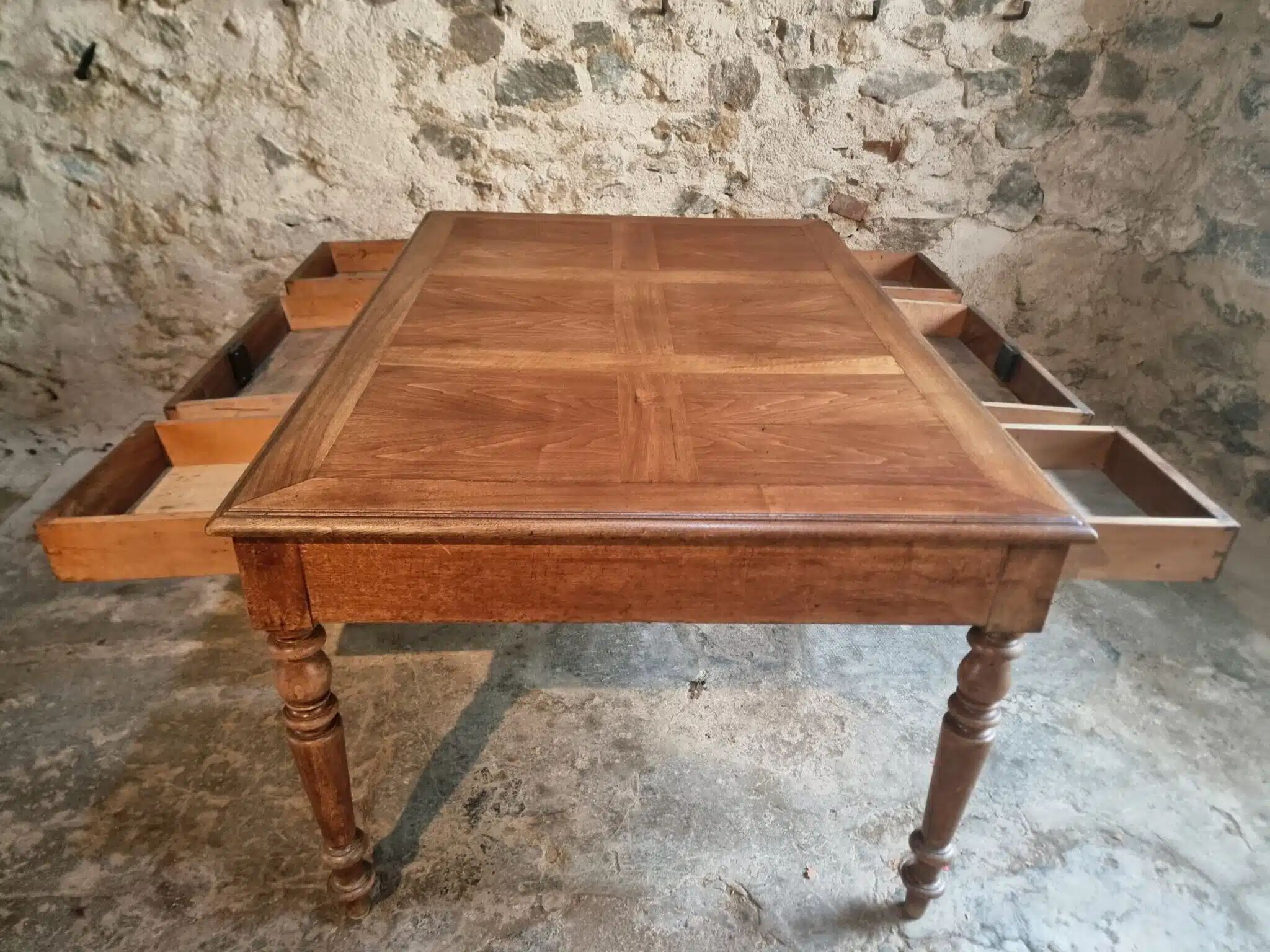 Antique French walnut table with six drawers, parquet top, early 20th century.