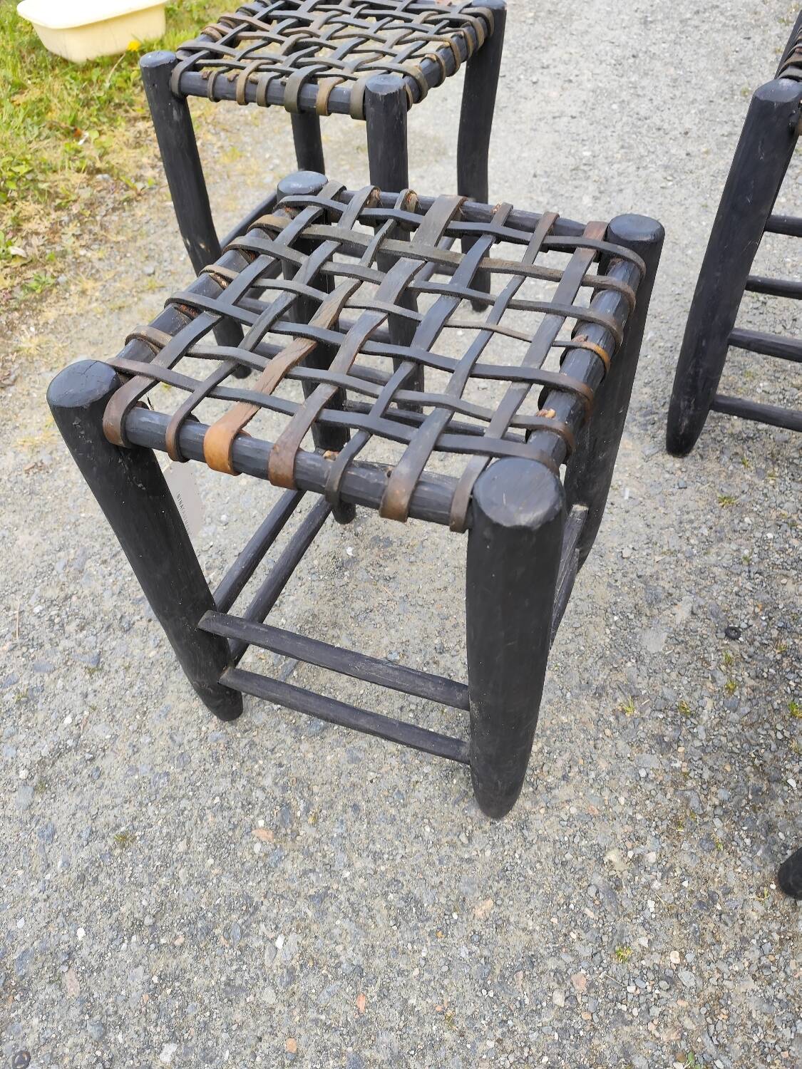 5 blackened wooden stools with woven leather seats by Nina Kaufmann