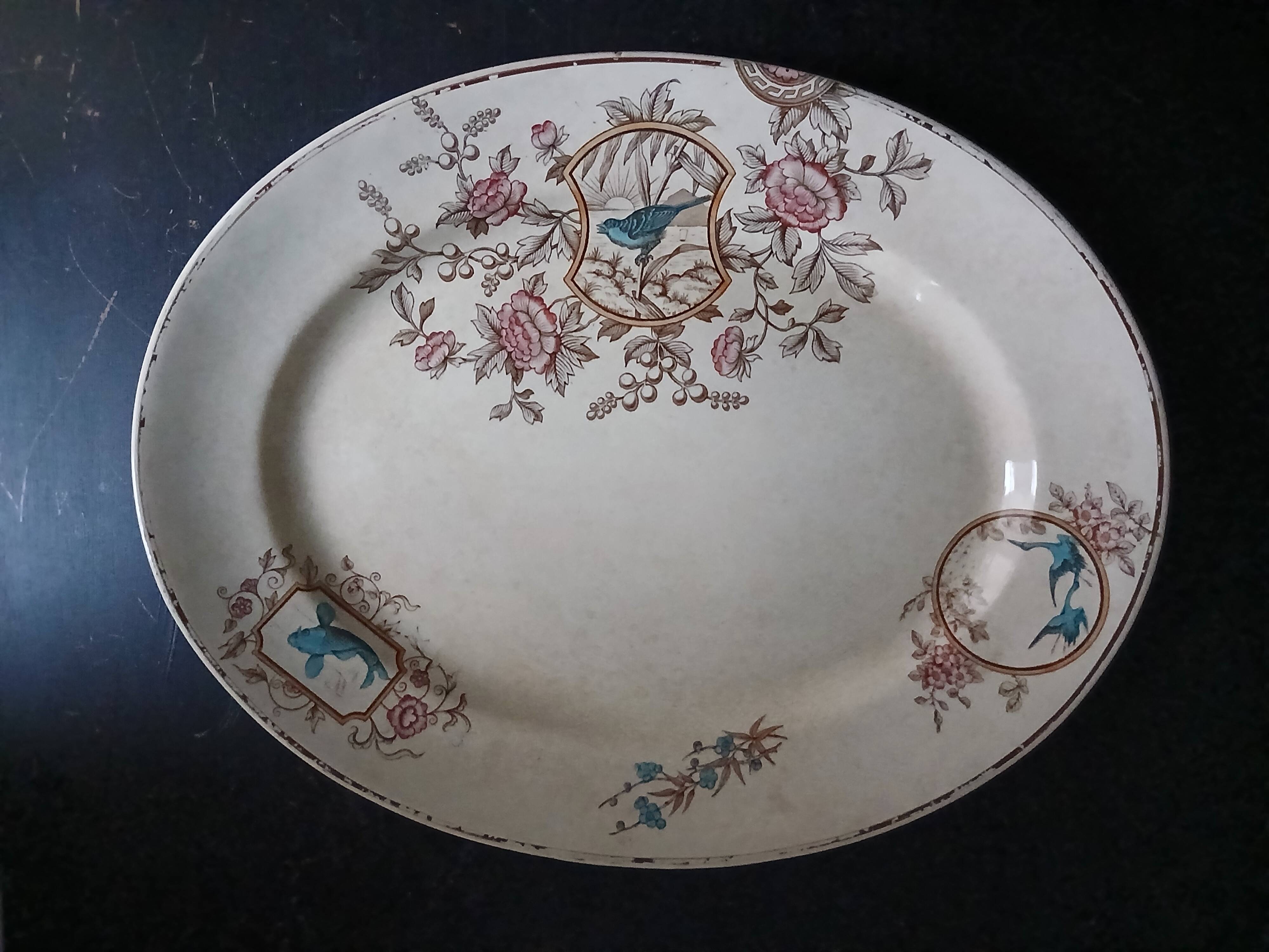 Large antique plate stamped with a fauna and flora pattern.