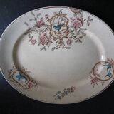 Large antique plate stamped with a fauna and flora pattern.