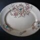 Large antique plate stamped with a fauna and flora pattern.