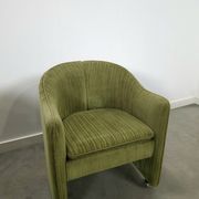 Chaises de cocktail vertes avec des roues chromées.