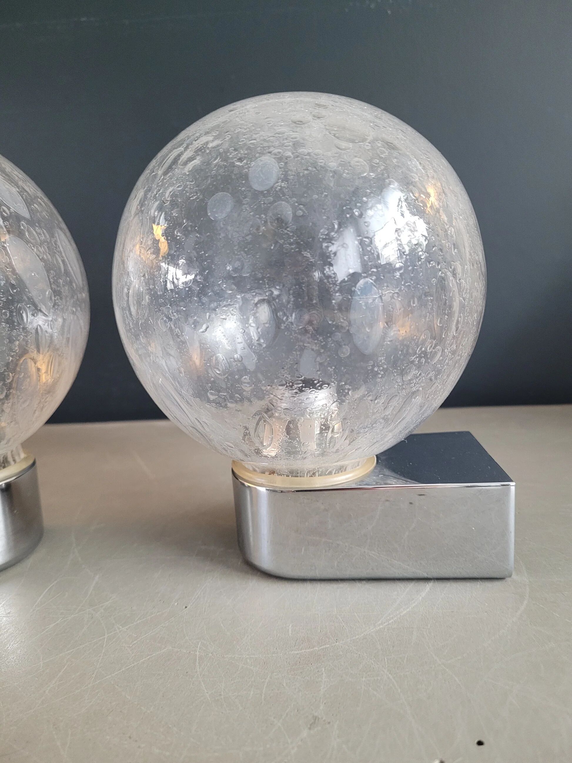 Pair of vintage wall lights in chrome metal with bubbled glass globes.