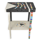 Table topped with a ceramic mosaic featuring an abstract design.