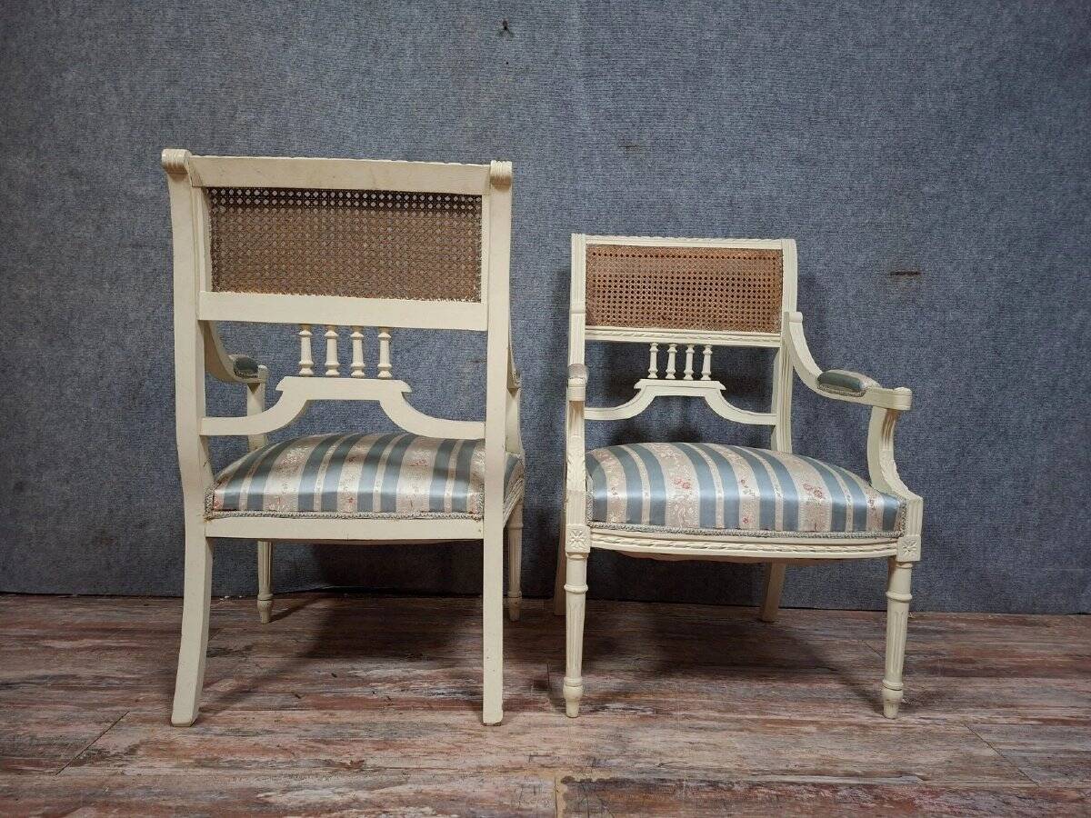 a pair of caned armchairs in the Louis XVI style, elegant and full of charm.