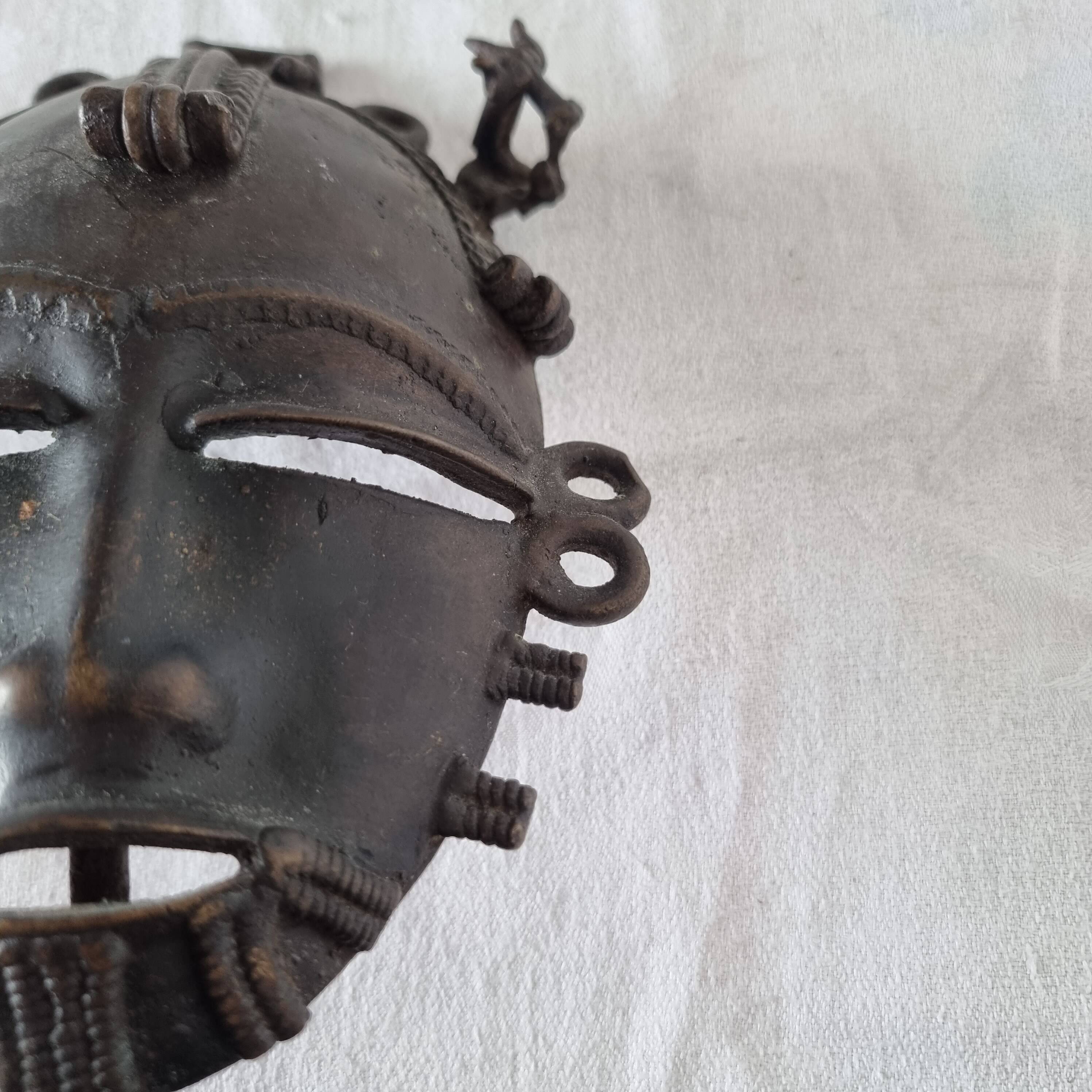 African bronze mask on pedestal, from Ivory Coast, dating