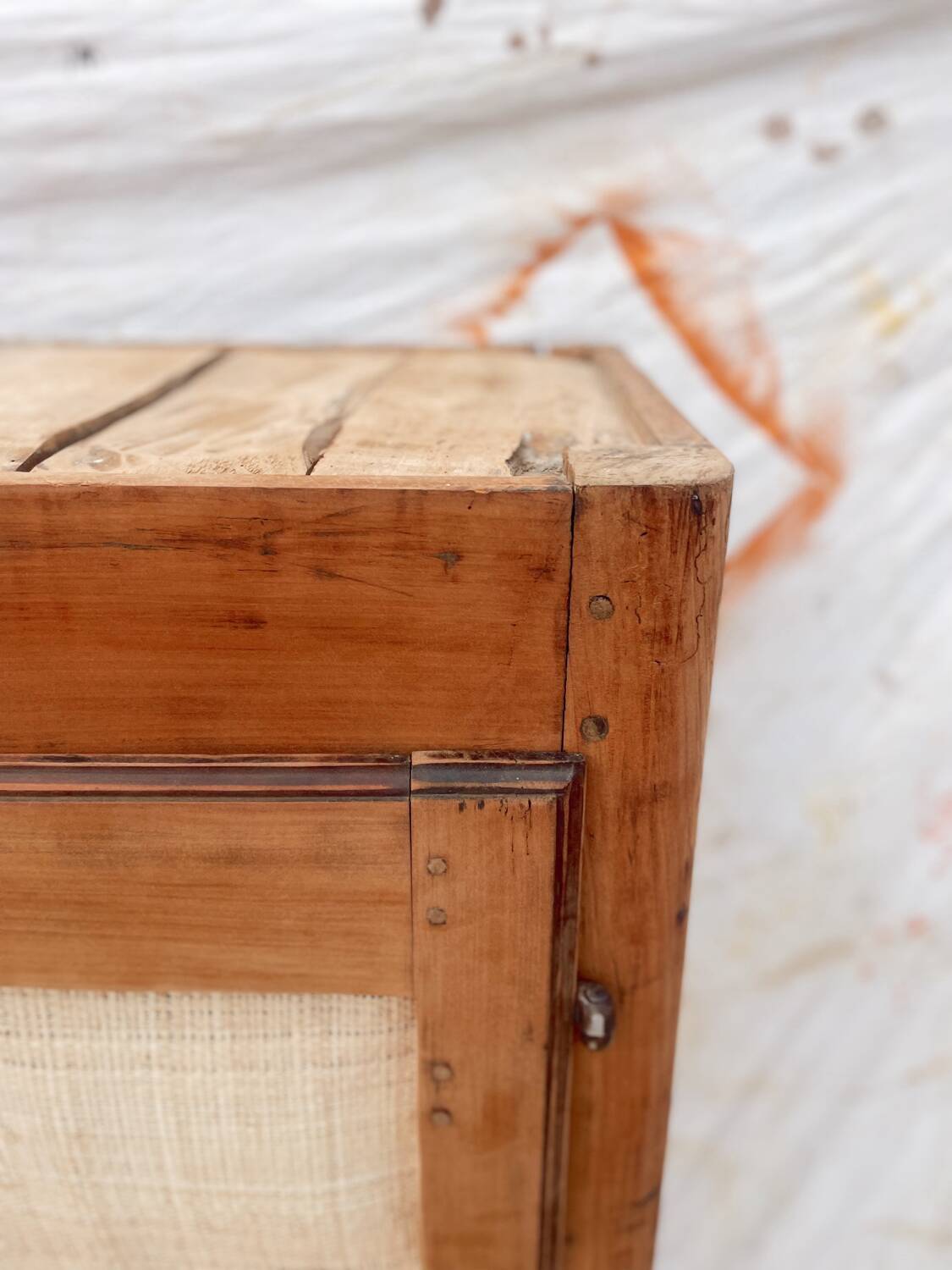 Low cabinet in raw wood and woven raffia.