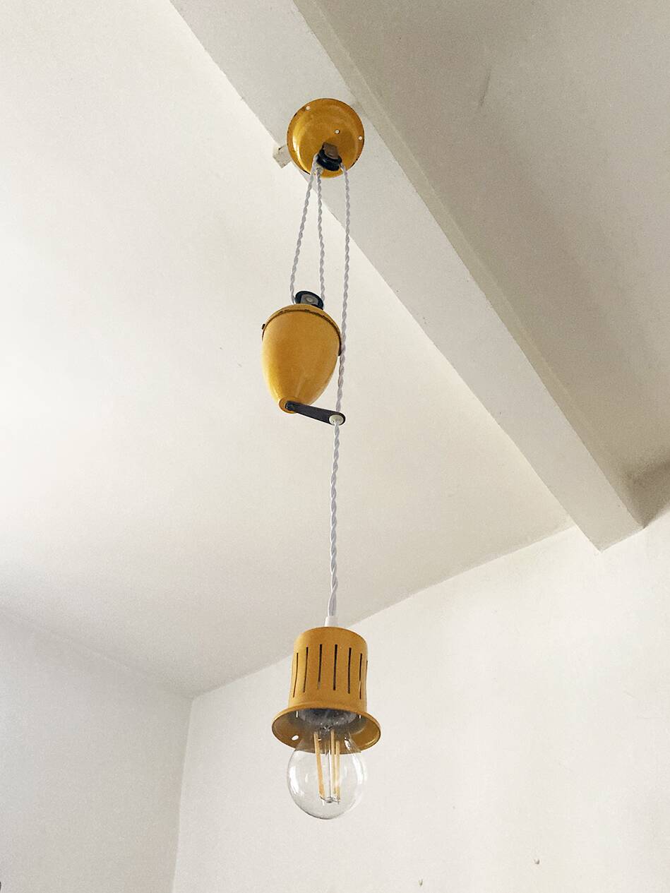 Suspension rises and falls in yellow painted metal