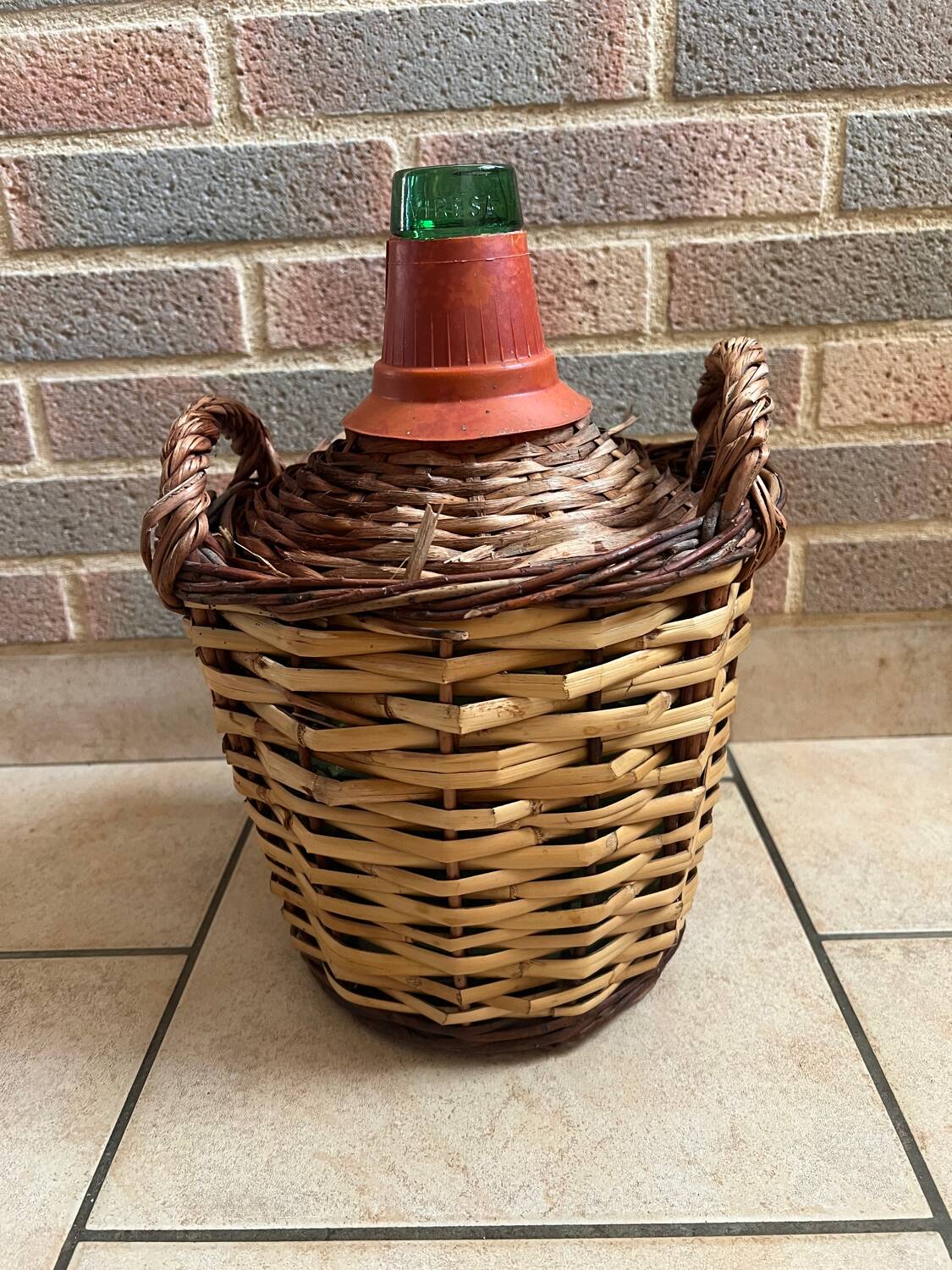 Old glass demijohn with wicker basket.