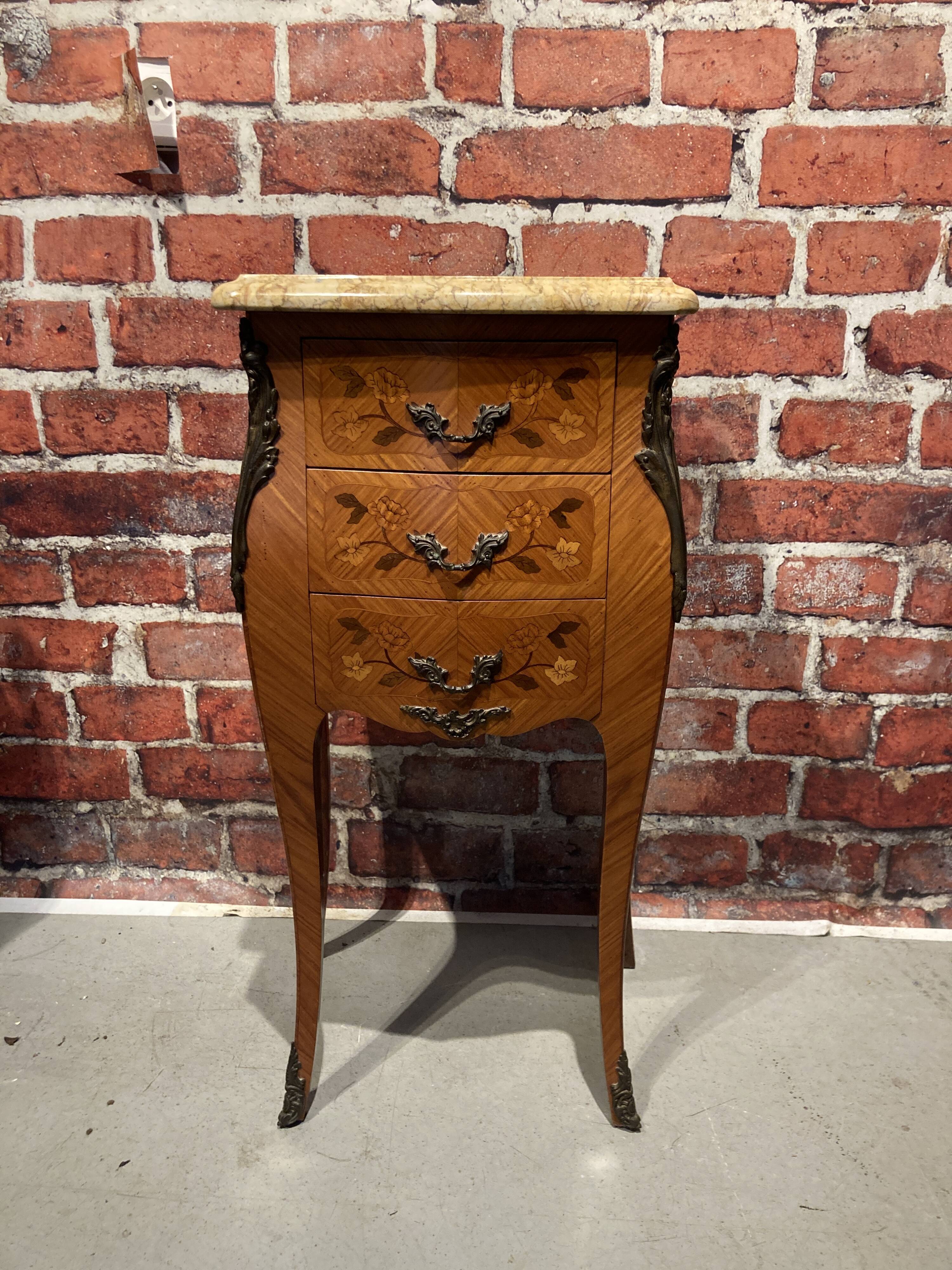 Wooden bedside table topped with a pink marble top