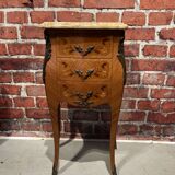 Wooden bedside table topped with a pink marble top
