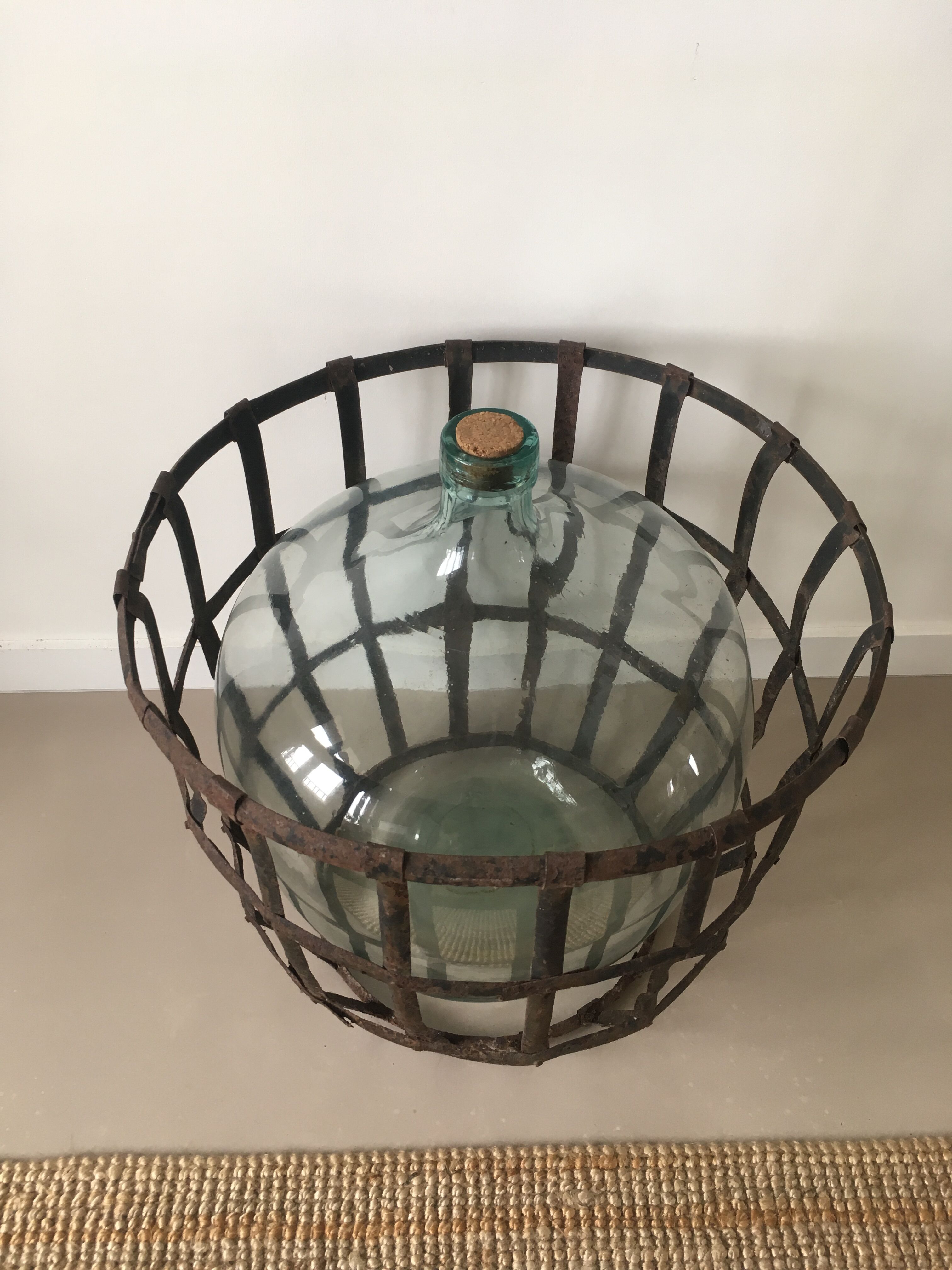 Old demijohn and her metal basket