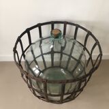 Old demijohn and her metal basket