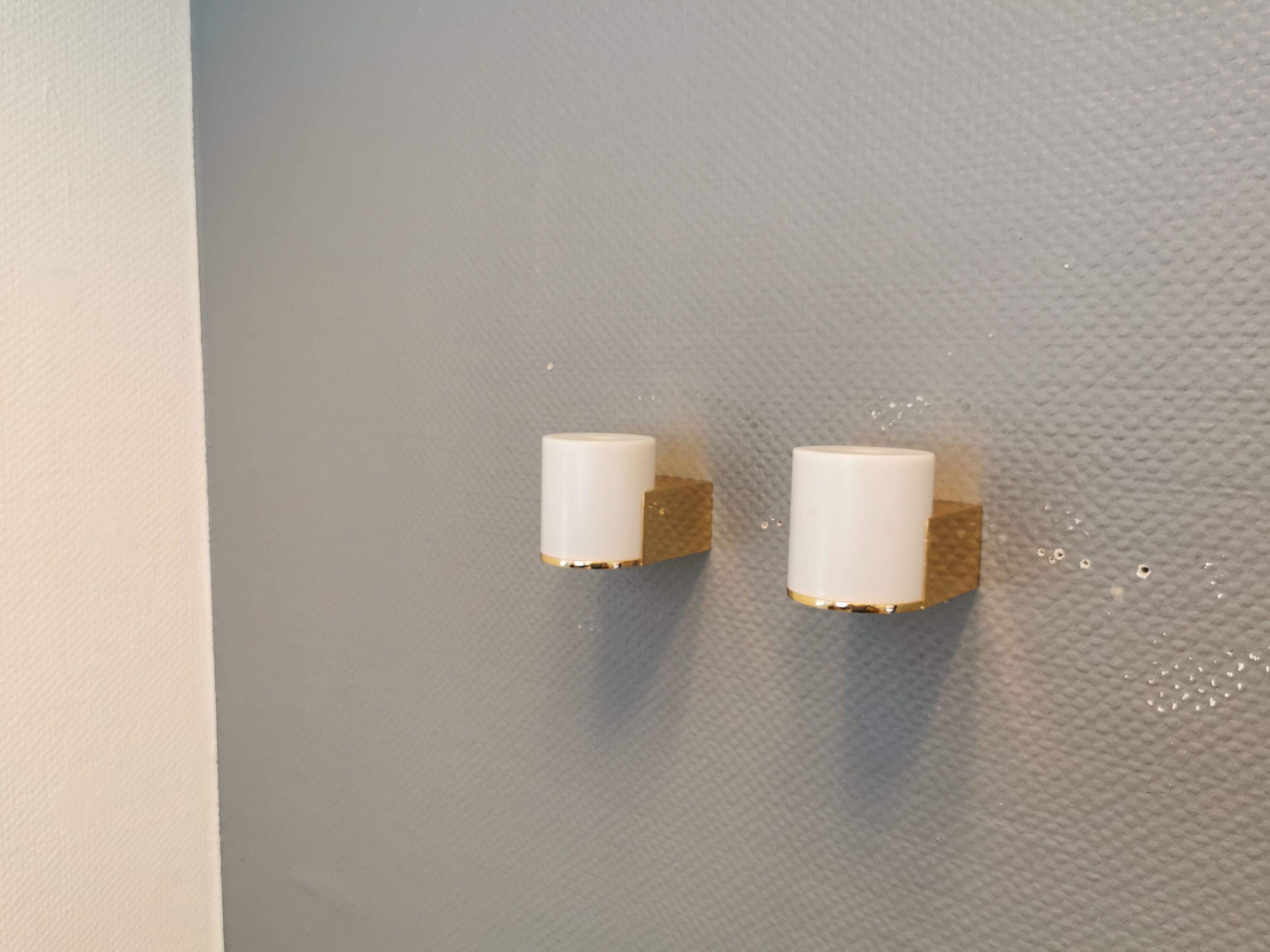 Wall lamps with milky white acrylic plastic shades and solid brass bases
