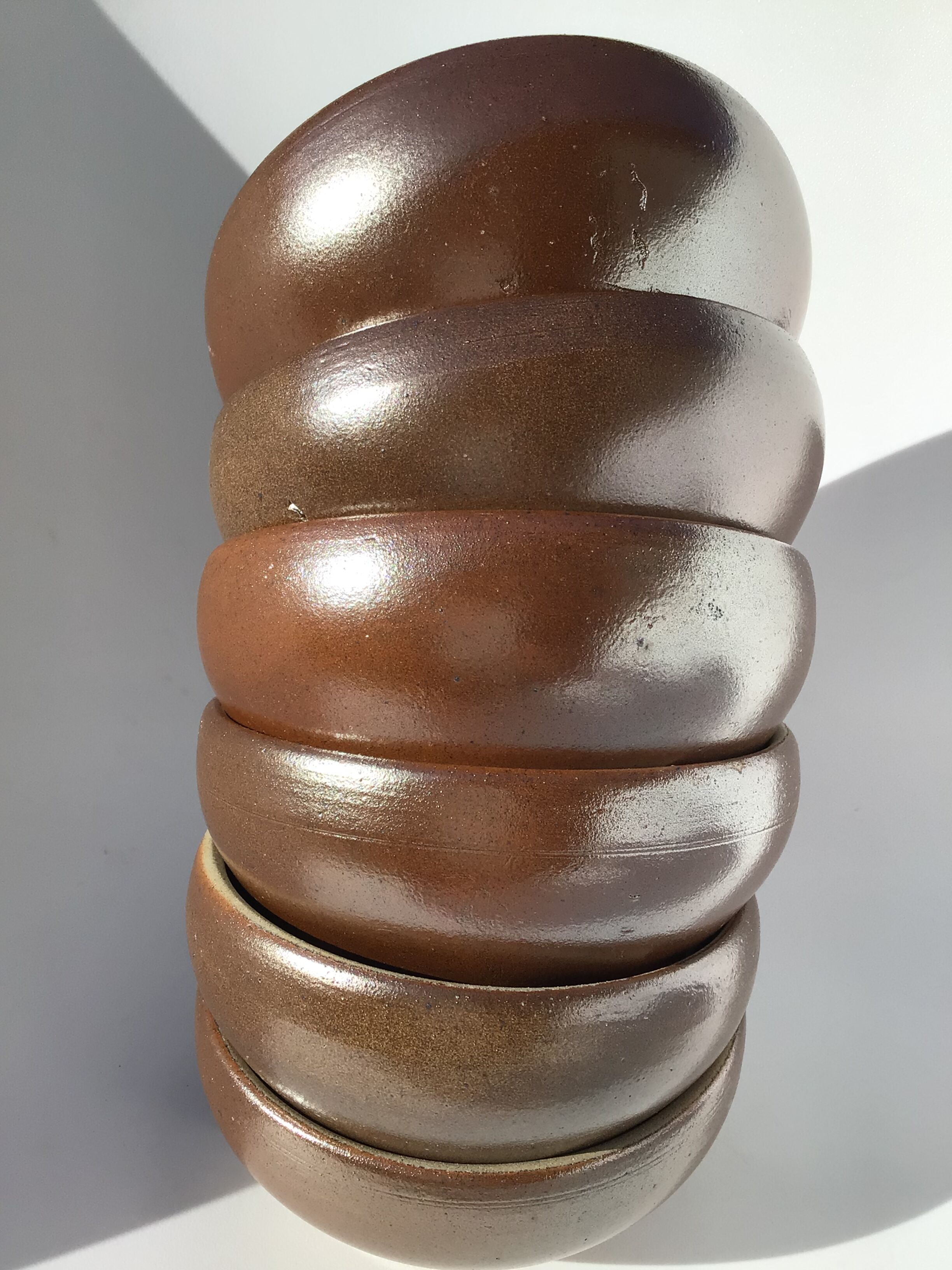 6 iridescent brown sandstone bowls inside grey