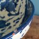 Empty pocket bowl in terracotta, glazed with "ink spots" design.