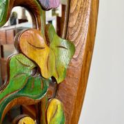 Carved wooden mirror with flower decorations.