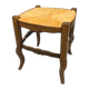 Rustic wooden stool with a straw seat.