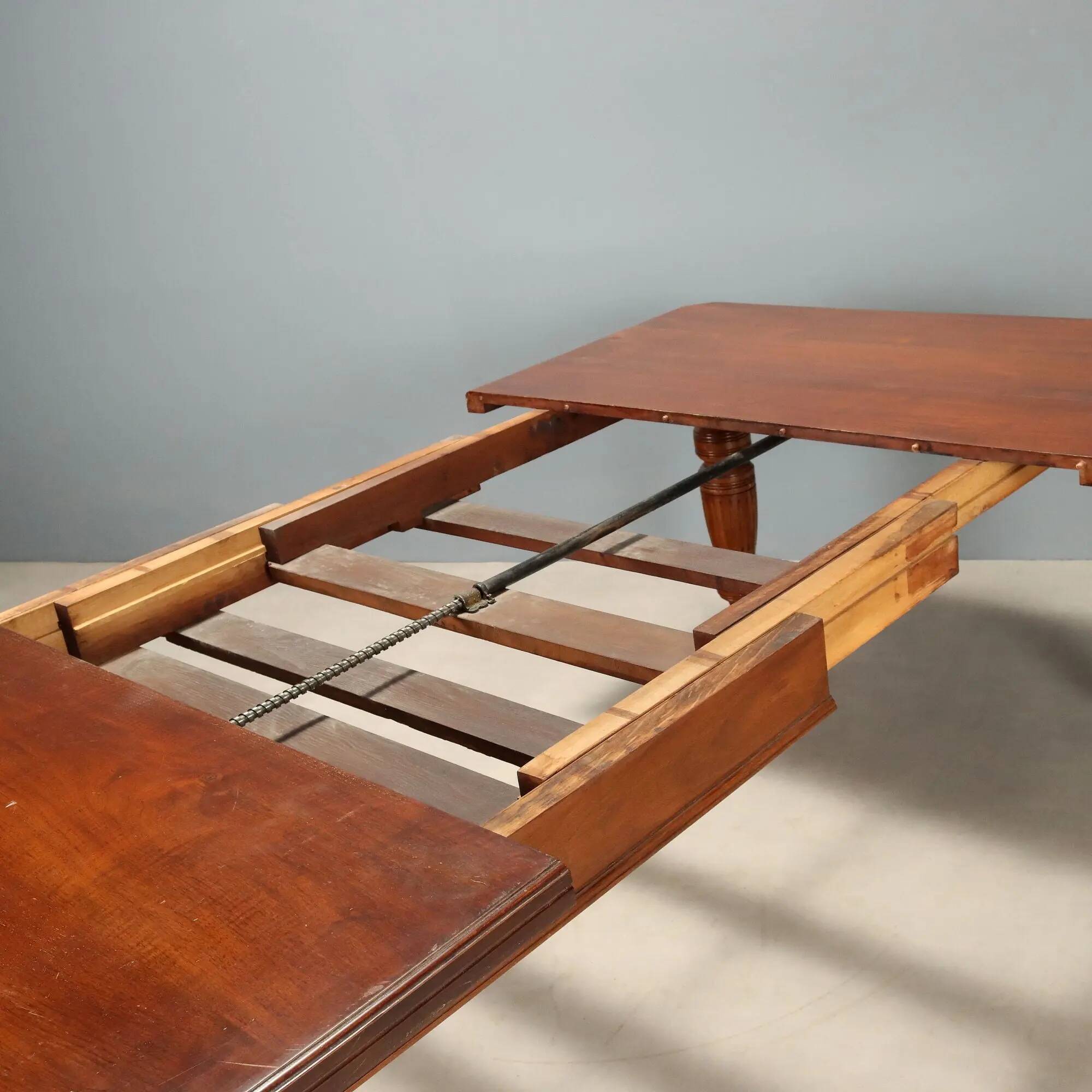 Antique extendable mahogany table with a crank mechanism, United Kingdom.